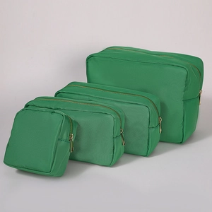 Detailed set of four green nylon toiletry bags in varying sizes with golden zippers