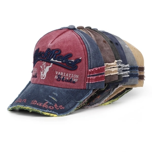 Close-up of stacked vintage washed denim baseball caps with Black Rebel embroidery