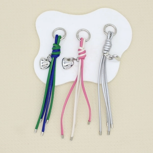 Macro view of woven tassel keychain charms with polished heart pendants and spring clasps