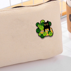 Cute black cat enamel brooch with green button and yellow yarn on beige canvas bag