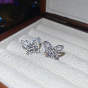 Detailed close-up of sparkling zircon butterfly stud earrings in a luxury jewelry box