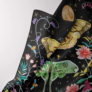 Detail of bohemian tree of life tapestry with moth, flower and moon patterns on black fabric
