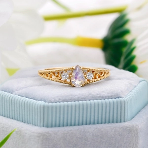 Macro detail of drop-shaped moonstone ring with side diamonds and vintage gold engraving