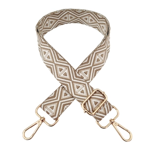 Detail of adjustable geometric jacquard bag strap with golden metal hooks and buckles