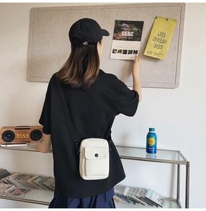 Lifestyle shot of a minimalist white crossbody phone bag worn in a casual setting
