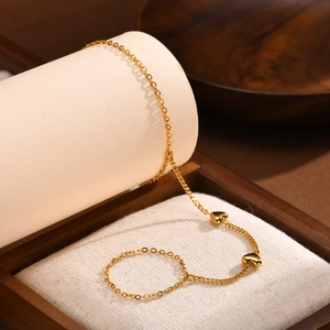 Detail of 18K gold-plated double-layered chain bracelet with polished heart charms