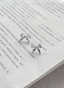 Macro shot of silver bow stud earrings in 925 sterling silver with polished finish