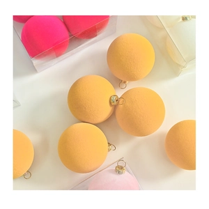 Detail of 6cm macaron flocked Christmas balls in pink, yellow, and white with gold rings