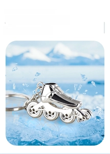 Detail of silver zinc alloy roller skate keychain on ice with snowy mountain backdrop