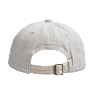 Detail view of adjustable metal buckle and distressed fabric on a beige baseball cap
