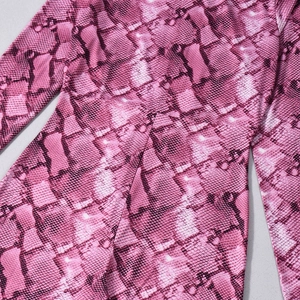 Dettaglio della trama a serpente rosa sul tessuto elastico di un body a maniche lunghe