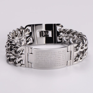 Macro detail of stainless steel Cuban chain bracelet with Spanish Lord's Prayer engraving