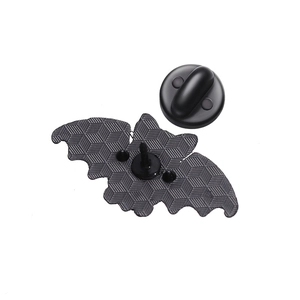 Detailed macro view of the black metal bat-shaped brooch backing with hexagonal texture