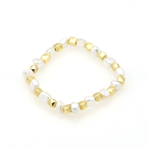 Detail of elegant white pearls and 18k gold-plated geometric cubes on a beaded bracelet