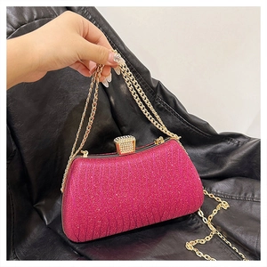 Pink evening clutch bag with glitter texture, gold chain, and rhinestone buckle detail