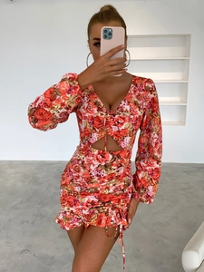 Détails d'une robe fleurie avec manches bouffantes, décolleté en V et découpes