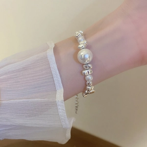 Close-up of pearl and irregular silver metal bead bracelet on a female wrist