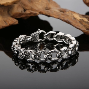 Detail of punk double-row skull chain bracelet with vintage finish on black mirror