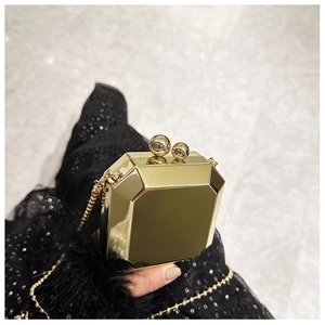 Detail of octagonal gold acrylic clutch bag with a metallic finish and chic bead chain strap