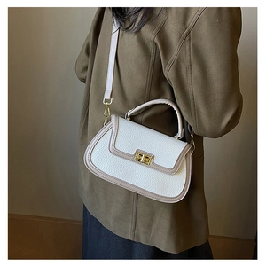 Détail du sac en cuir PU blanc et beige avec texture grainée et boucle en métal doré