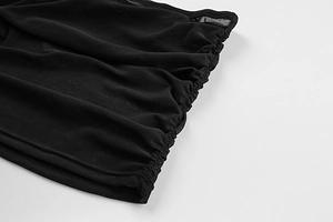 Close-up of black mesh fabric detail showing elastic ruched texture and pleated seams