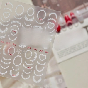 Macro detail of MS-723 nail stickers featuring white lace and red bow designs