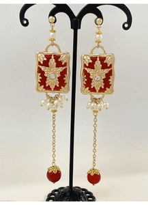 Detail of vintage palace style earrings with red resin and star floral engraving