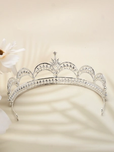 Detail of silver vintage bridal crown with intricate cutout design and star ornaments