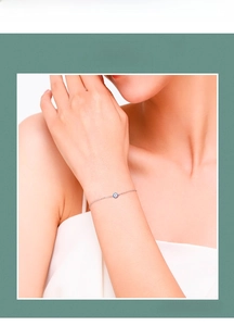 Detail of s925 silver bracelet featuring a blue evil eye charm on a delicate chain