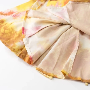 Dettaglio del morbido tessuto tie-dye con cuciture fini su un abito con scollo all'americana
