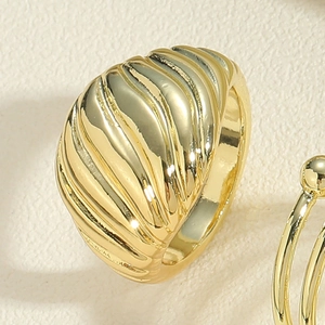 Macro detail of golden chunky ring featuring a vintage spiral croissant wave texture