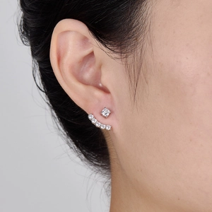 Macro detail of 925 silver stud earrings with zirconia curved ear jacket worn on ear
