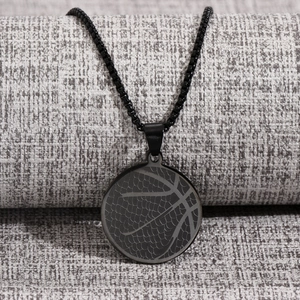 Detailed close-up of matte black basketball pendant necklace with etched texture