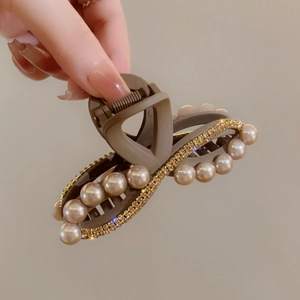 Dettaglio della grande pinza per capelli marrone in acrilico con perle e strass