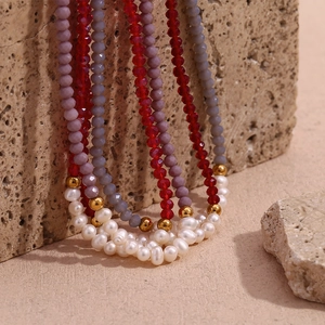 Detailed macro shot of red crystal beads and white pearls on a layered beaded necklace