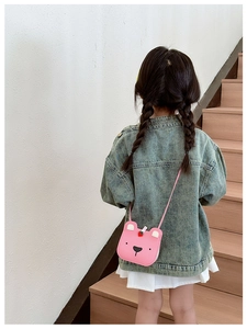 Pink bear-shaped crossbody bag shown on a young girl wearing a denim jacket