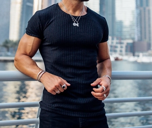Detail of black slim-fit ribbed t-shirt with metal necklace and bracelet on model