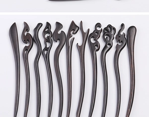 Detailed view of various hand-carved ebony wood hairpins with traditional Chinese patterns