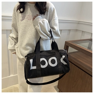 Detailed shot of a large black nylon travel bag with white LOOK lettering and dual straps