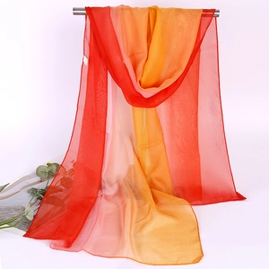 Detail of thin gradient chiffon scarf showing translucent texture and orange-pink tones