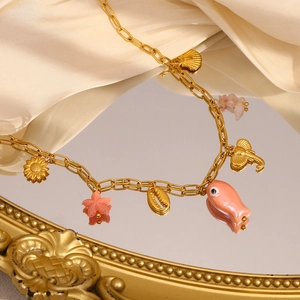 Detailed shot of 18K gold plated necklace with pink starfish and sea shell pendants