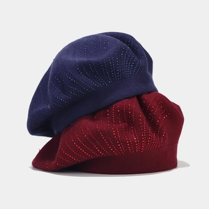 Détail de bérets en tricot bleu marine et bordeaux avec des accents de strass brillants