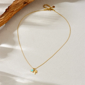 Gold stainless steel necklace with blue starfish and plane charms on wood
