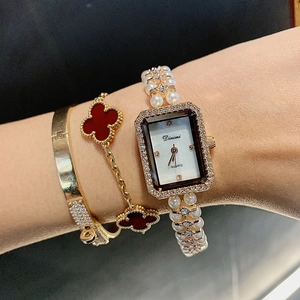 Detail of square shell dial watch with crystal bezel and elegant pearl bracelet band