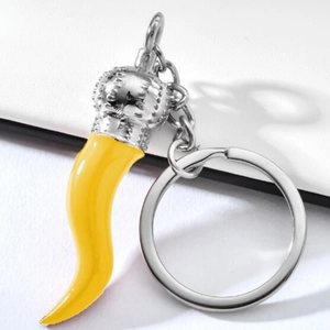 Macro shot of yellow Italian cornicello chili pendant with silver crown metal ring
