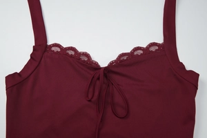 Macro detail of wine red lace trim and lace-up neckline on the sleeveless top
