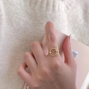 Close-up of golden 925 silver knot ring featuring a minimalist OT toggle clasp design