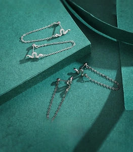 Macro detail of S925 sterling silver snake earrings with crystals and green stone eyes