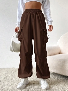 Detail view of high-waist dark brown cargo pants styled with white sneakers and crop top
