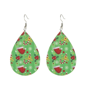 Macro detail of tear-drop faux leather earrings with festive green holiday patterns